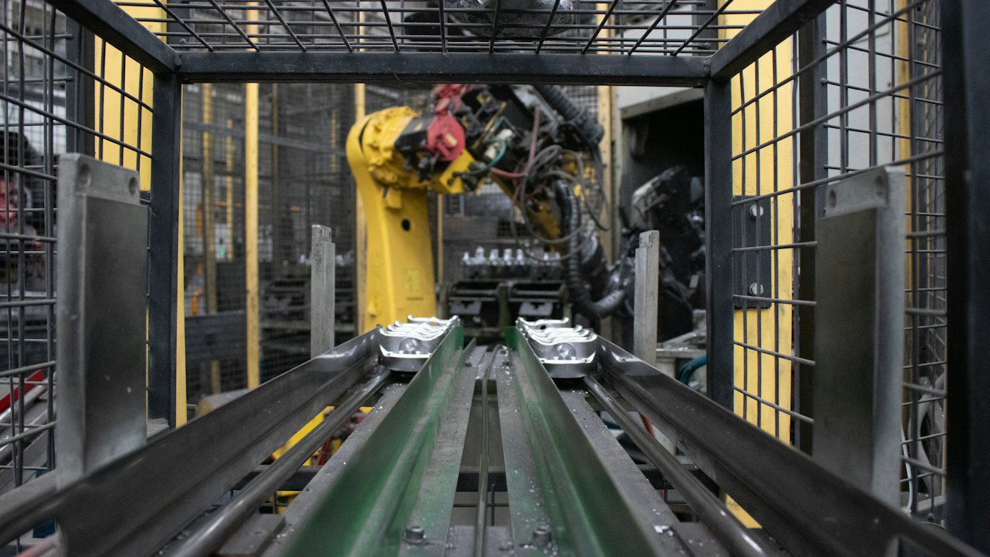Brazo robótico trabajando en línea de producción con cintas transportadoras.